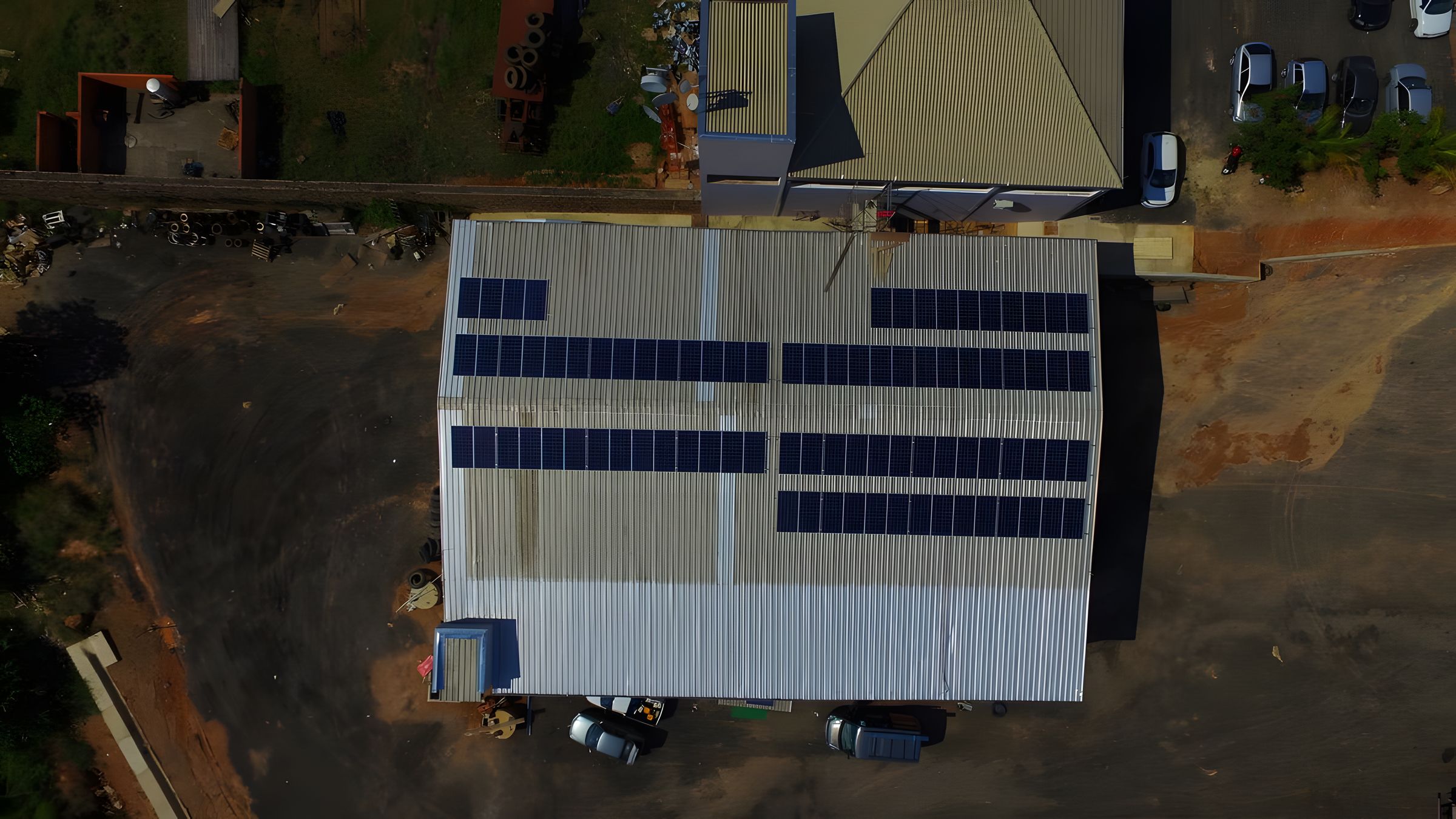 Vista aérea de galpão comercial com módulos fotovoltaicos ocupando o telhado